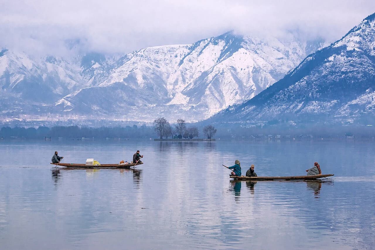 Boats on a quiet lake beneath Srinagar’s snowy mountains